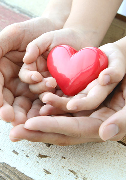 Red heart in child and mother's hands Red heart in child and mother's hands